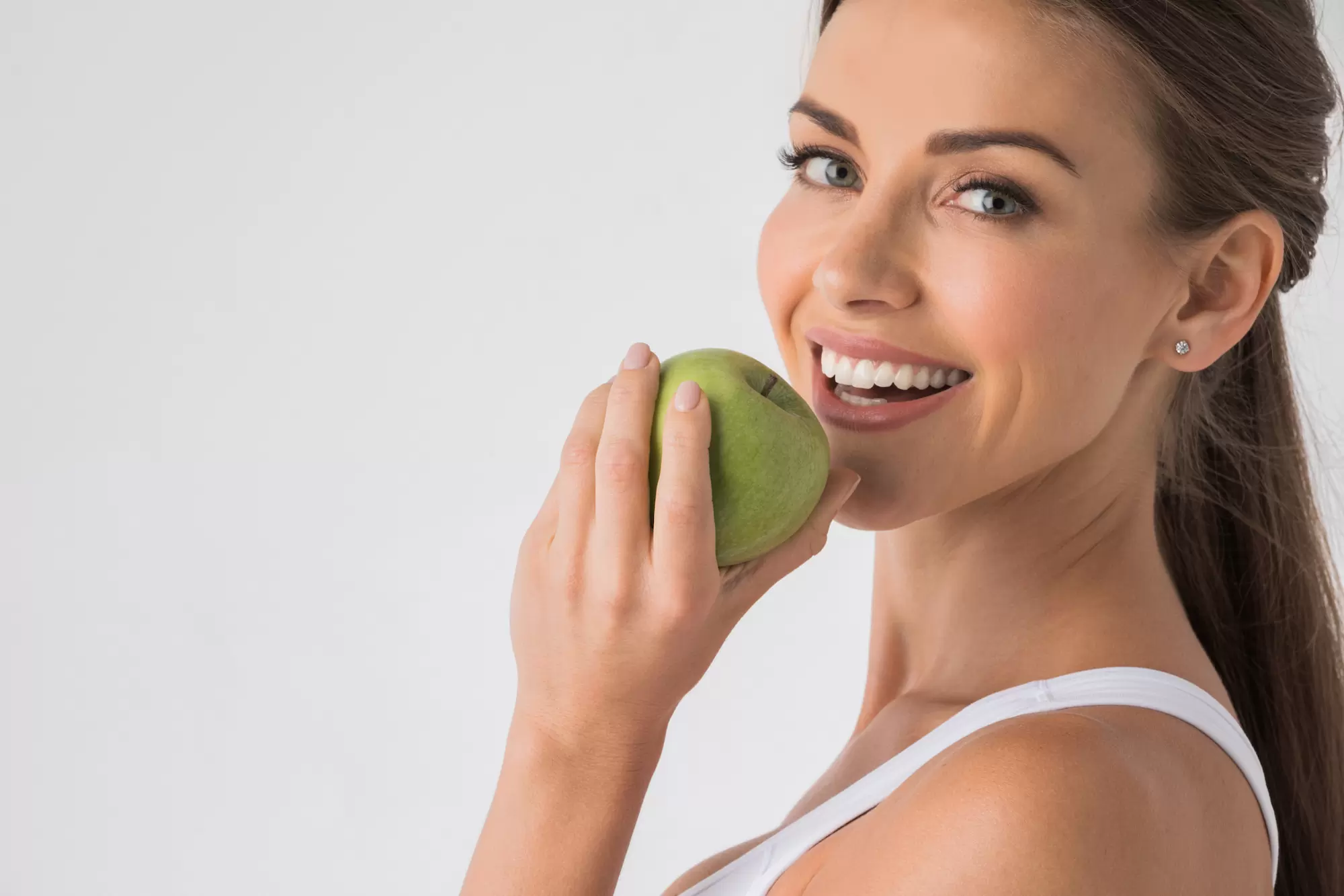 Woman biting green apple denti fissi in 24 ore